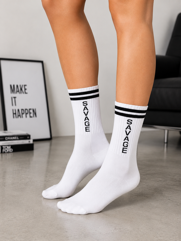 White crew socks with black stripe detail and vertical SAVAGE text design.