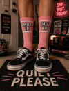 oft pink crew socks with bold “SHUT UP” text design in white and black, finished with sporty white stripe details near the cuff.