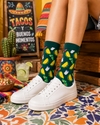 Green crew socks with colorful taco, avocado, chili, and drink illustrations in a fun Mexican food theme.