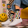 White crew socks with colorful thumbs up pattern in green, yellow, and blue.