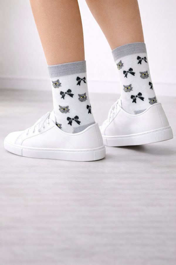 Pair of white crew socks with grey cuff, heel and toe, featuring grey cat and black bow pattern, unisex breathable socks