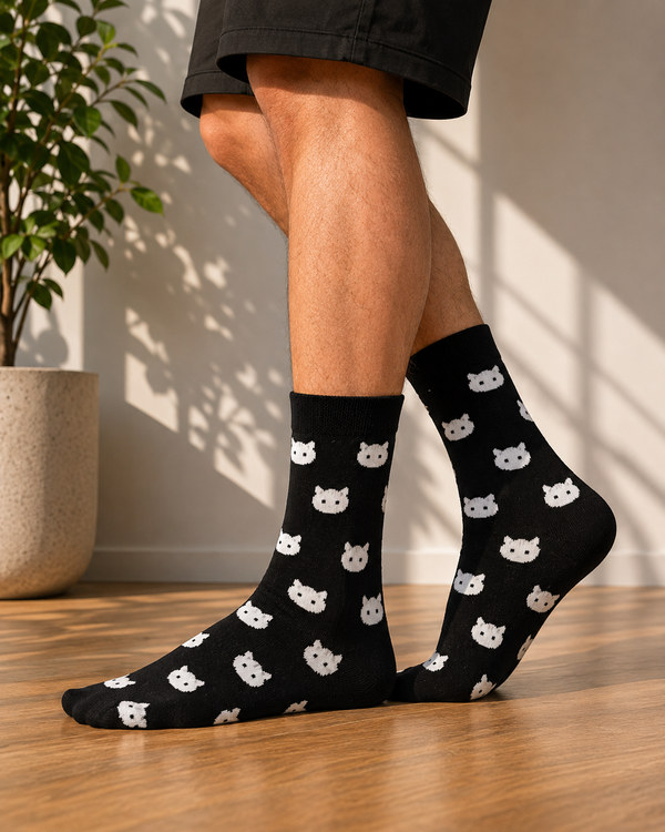 Black crew socks featuring an all-over pattern of white cat faces.